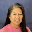 Jenny Ignacio is a Teacher of the Deaf at Listen and Talk's Blended Classroom Preschool Program for children who are deaf and hard of hearing. She has brown skin and dark hair and she is wearing a pink shirt.