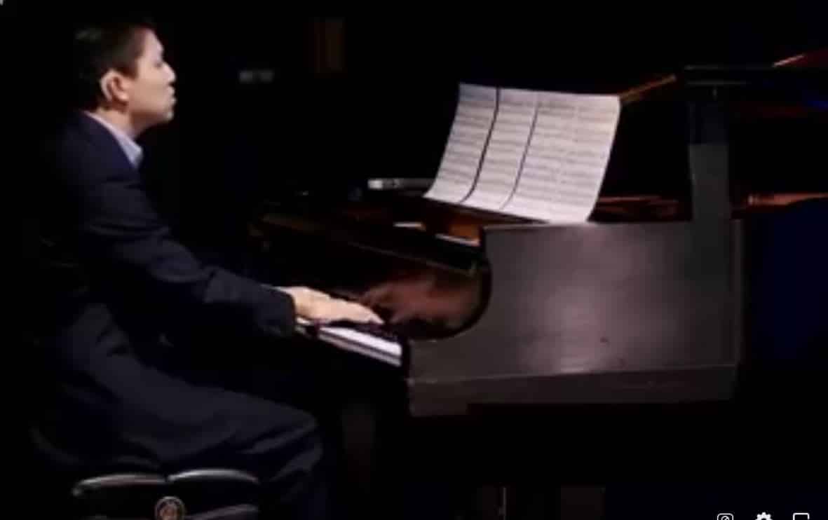 Listen and Talk alum, Max Wu playing a grand piano on stage at Listen and Talk's virtual gala in 2021