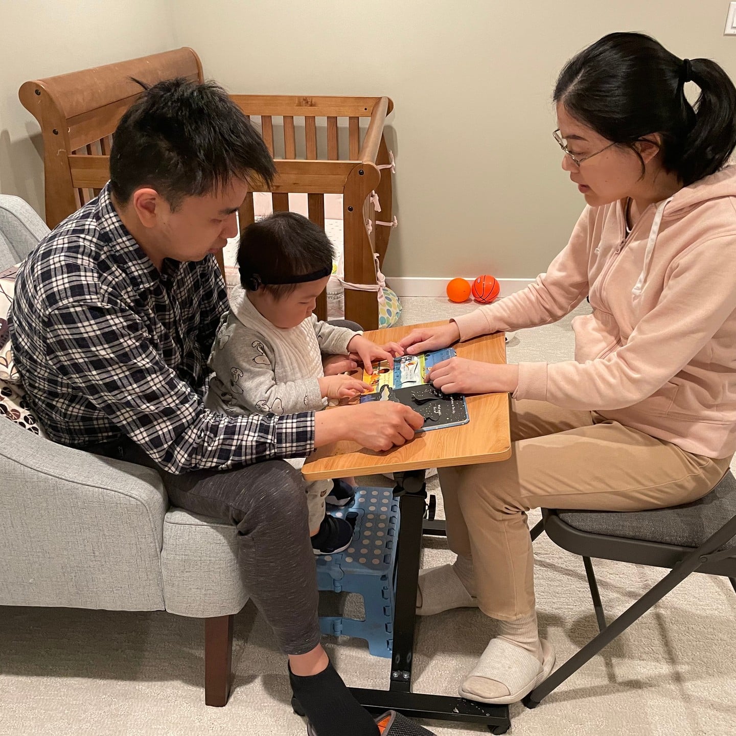 Our family coaching model encourages families to take the lead in their child's development. The family in the photo above is engaging with their child by reading to them.