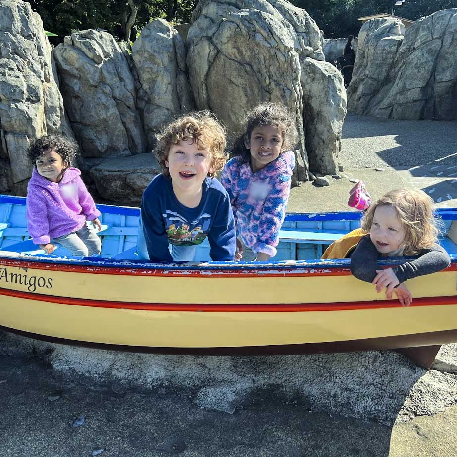 Four children sitting in an empty boat